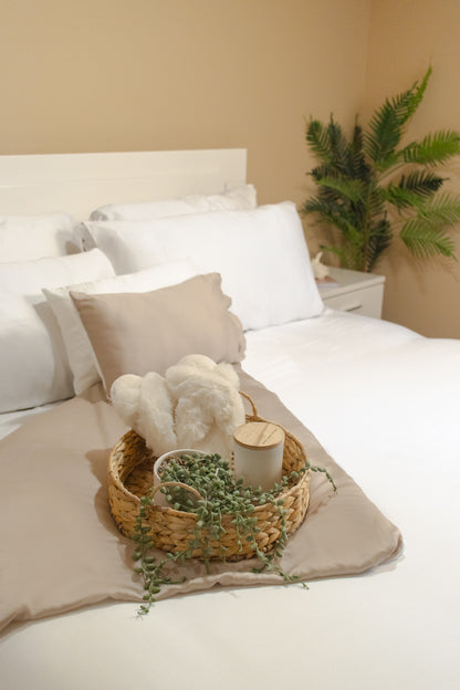 Farmhouse-style bedding set with rustic textured comforter and pillows on a wooden bed frame