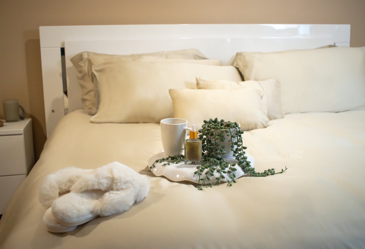 Neatly folded bedding set with ribbon, styled as a housewarming gift on a bed